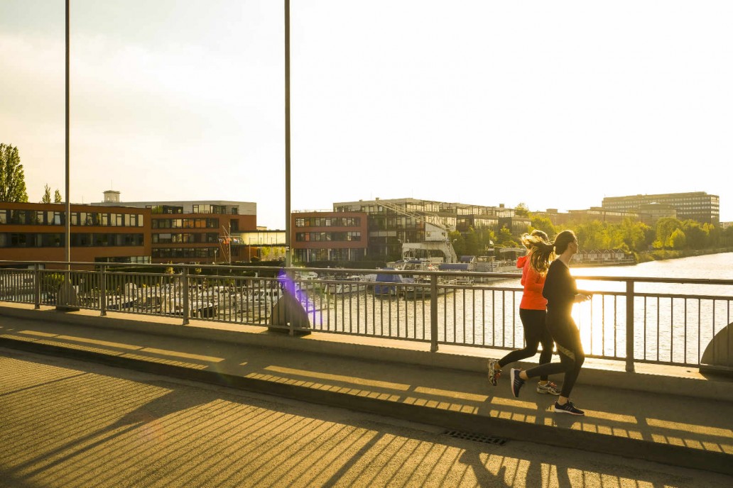 Zwei Personen joggen über Brücke in Hannover