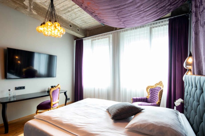 Suite mit Himmelbett im Loftstyle Hannover - Blick über das Bett um TV und Richtung Fenster